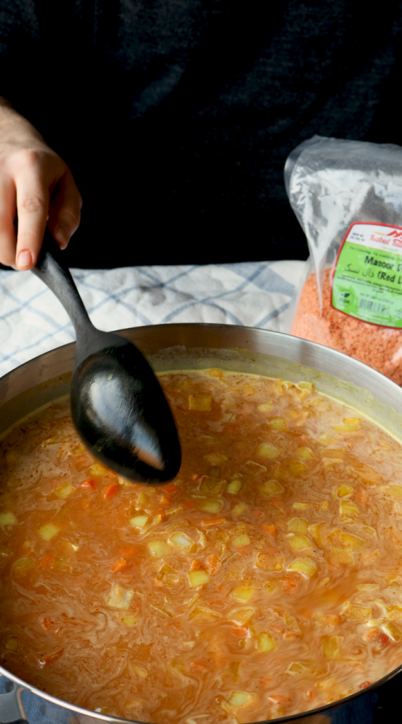 To make this creamy red lentil soup, begin by sautéing onions and minced garlic in oil. Then add carrots and seasonings. Cook for a few minutes, then add tomato paste, red lentils, and water. Bring to a boil, then cover and cook on super low for 30 minutes, or until lentils and carrots are soft. Blend until smooth, then add heavy cream. Add more heavy cream if a more soupy consistency is desired. Top with red pepper flakes and cilantro and enjoy!